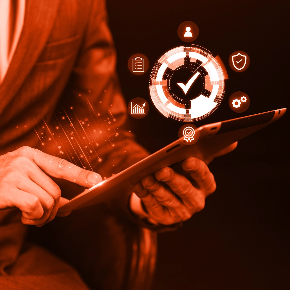 Employee reviewing compliance data on a tablet, illustrating regulatory compliance management.